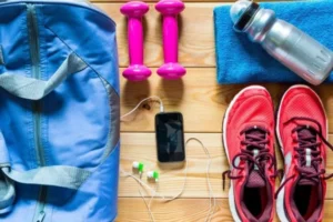 bolsa para carregar equipamentos celular e fones de ouvido dois halteres uma toalha um tênis e uma garrafa