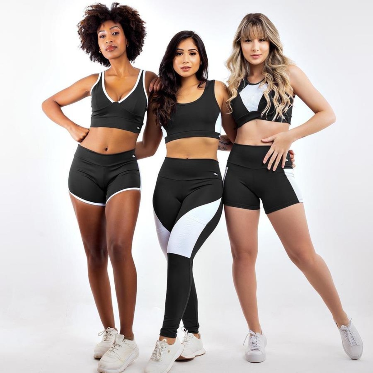 TRÊS MULHERES EM PÉ COM ROUPA DE ACADEMIA